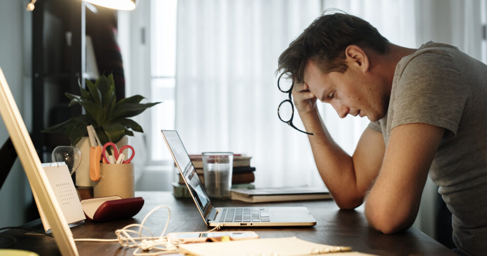Man stressed while working on laptop