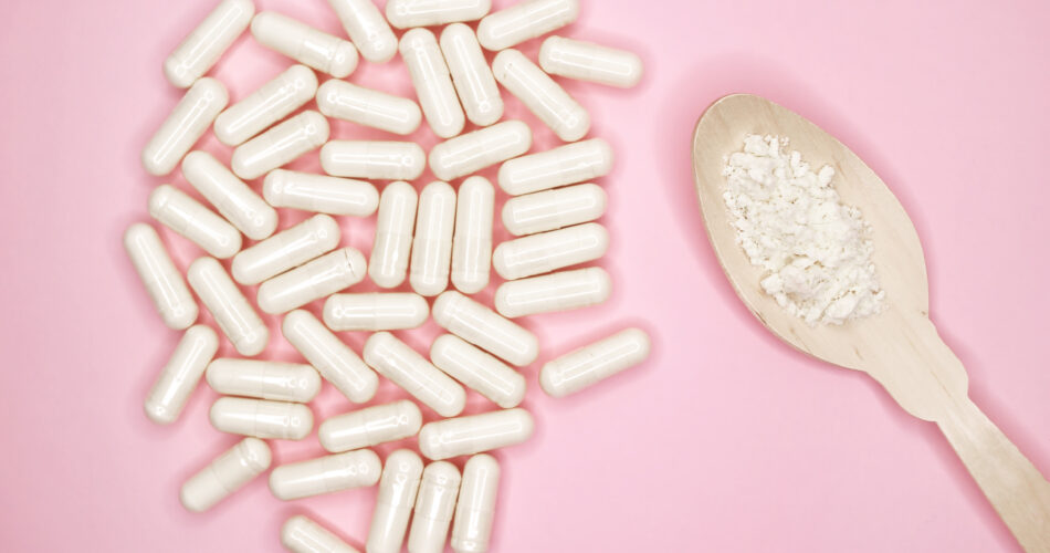 Capsule di pillole con colostro, su uno sfondo rosa