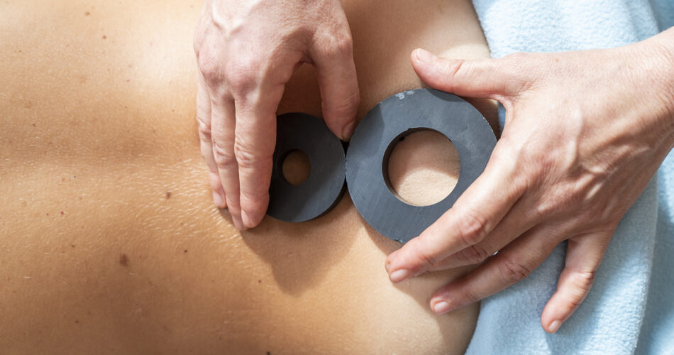 Frau bei einer Ayurveda-Massage. Körpermassagebehandlung mit Magnet für tiefe Entspannung.